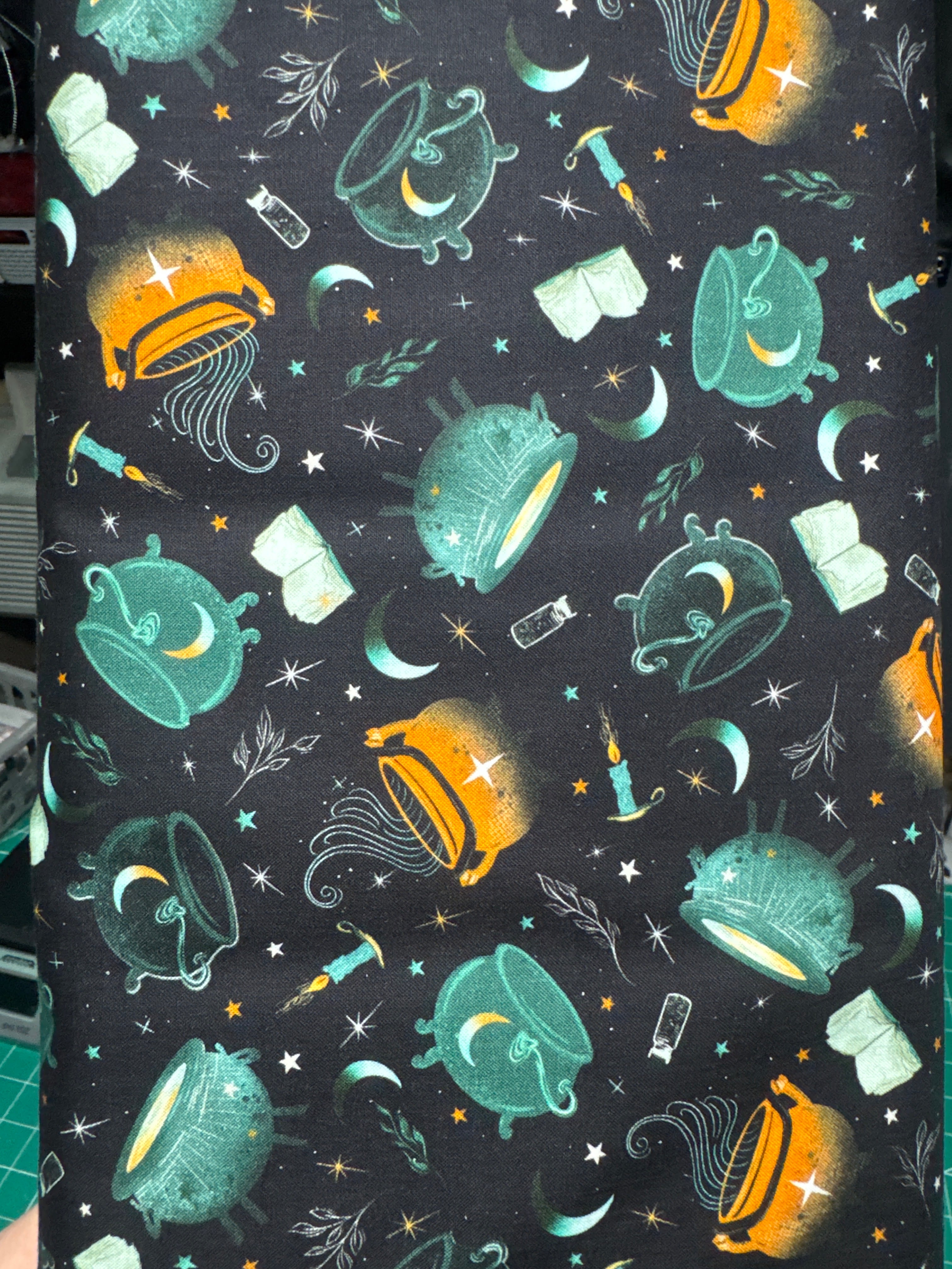 Witchy wicked cauldrons on a black background. Sold by the half yard.
