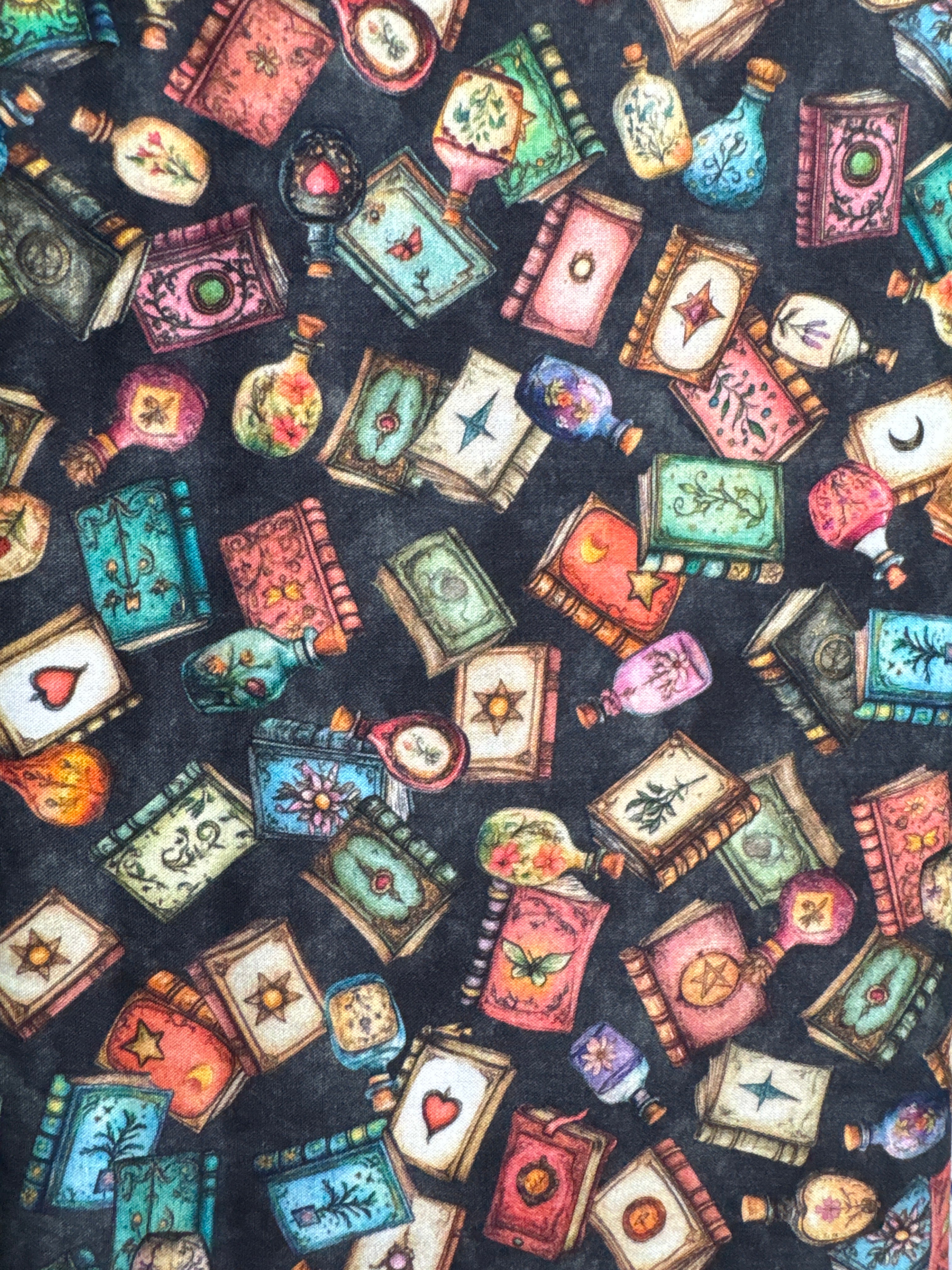 Withcypoo. Potion bottles and books. On a black background. Sold by a half yard. ￼
