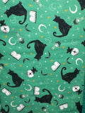Witchy wicked cats on a green background. Sold by the half yard.