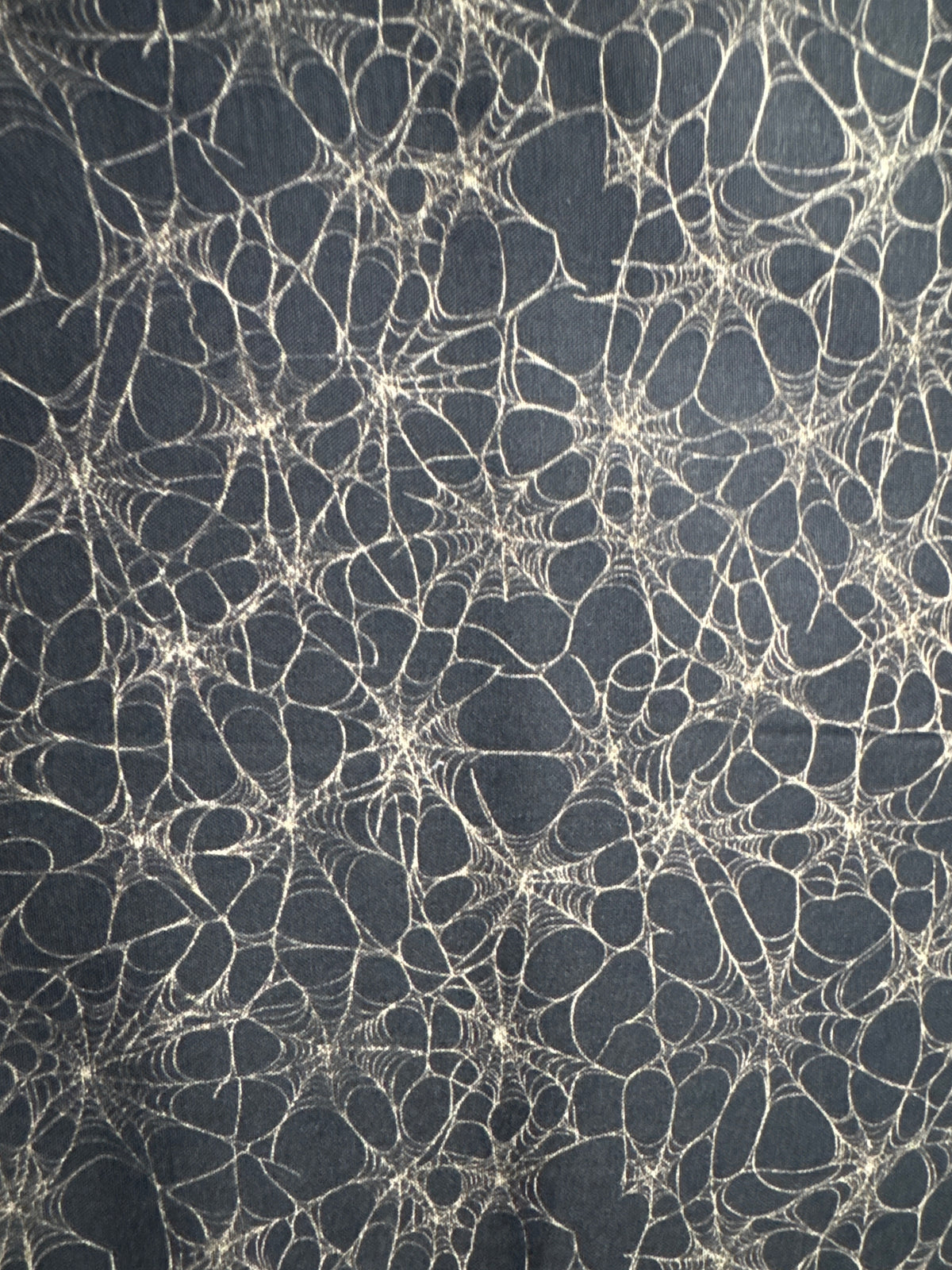 Witchypoo. Tan spiderwebs on a black background. Sold by the half yard. ￼