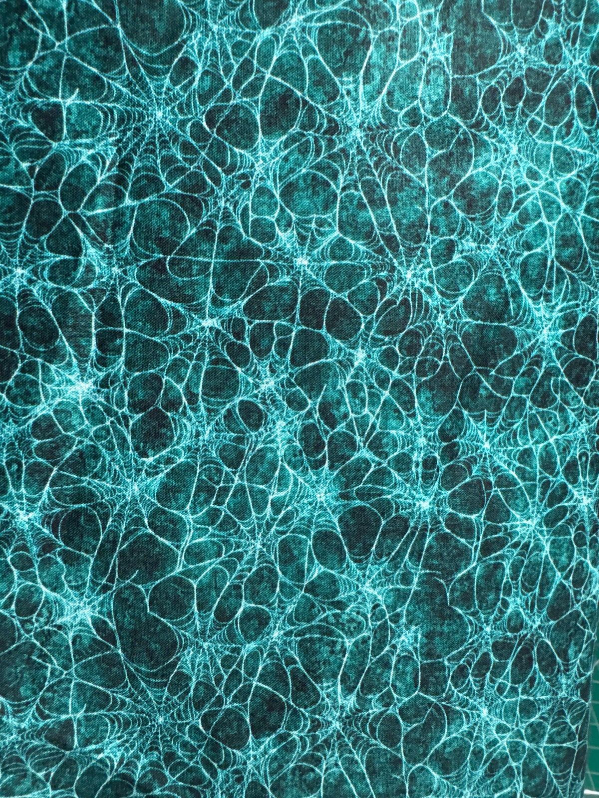 Witchypoo. Spiderwebs on a green background. Sold by the half yard.